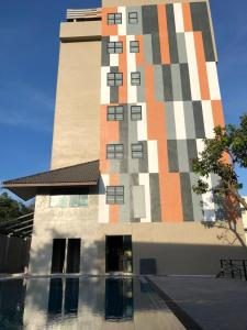 Pi MaiRabbit Hotel Phimai的一座高大的建筑,前面有一个游泳池