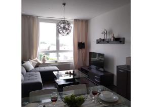 a living room with a couch and a table at Sunny Penthouse with roof gardens overlooking the Warsaw Palace of Culture in Pruszków