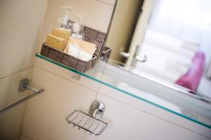a glass shelf on a bathroom door with boxes on it at Villa Andor in Ankaran