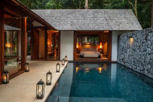 a villa with a swimming pool next to a bedroom at The Datai Langkawi in Teluk Datai
