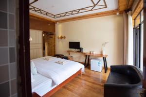 1 dormitorio con cama, escritorio y silla en Moganshan Bamboo View Guesthouse en Deqing