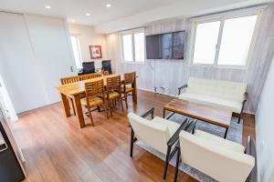 a living room with a table and chairs and a dining room at Port House Shibuya in Tokyo