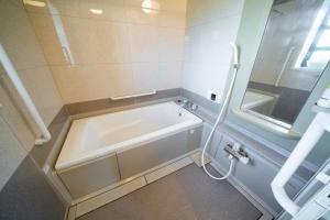 La salle de bains est pourvue d'une baignoire et d'une fenêtre. dans l'établissement Hachijyo-island Blue Eight -八丈島ブルーエイト-, à Mitsune