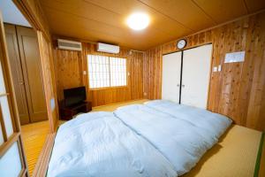 a bedroom with a large bed and a tv at Hachijyo-island Blue Eight -八丈島ブルーエイト- in Mitsune