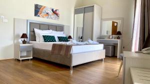 ein Schlafzimmer mit einem großen Bett und einem Spiegel in der Unterkunft Hotel Olimpija plus in Herceg-Novi