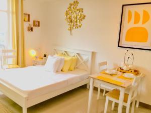 1 dormitorio con cama blanca y mesa en BH Mangrove Condos en Isla de Mactán