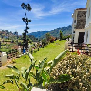 a view of a field of grass with a building at KBS Sree Paradise Kodai in Kodaikānāl