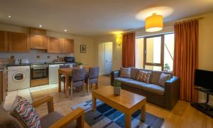 a living room filled with furniture and a kitchen at Clifden Station House Hotel in Clifden