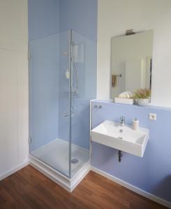 a bathroom with a glass shower and a sink at Hotel Reverey * kontaktloser Self Check-In * in Hannover