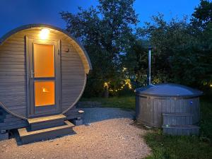 a circular sauna and a trash can at night at Skrunda Apartments Centrum in Skrunda