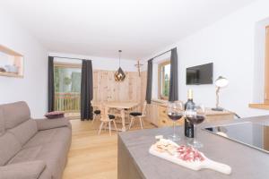 sala de estar con sofá y mesa con copas de vino en Ferienwohnung Berg Wieserhof, en Aldino