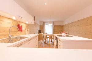 a kitchen with white cabinets and a sink and a table at Ferienwohnung Schupf Wieserhof in Aldino