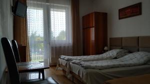吉波瓦的住宿－Na Fali，一间卧室设有两张床和窗户。