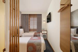 um quarto de hotel com duas camas e uma janela em Holiday Inn Express Bengaluru Yeshwantpur, an IHG Hotel em Bangalore