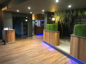 沃尔索尔贝弗利酒店的大堂设有绿色椅子和木地板