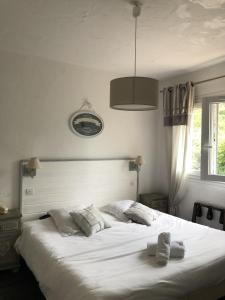 a bedroom with a large white bed with two pillows at Logis La Bastide des Golfs in Mouans-Sartoux