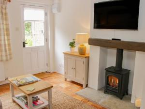 a living room with a fireplace and a flat screen tv at Wattle Cottage in Malpas