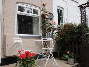 patio z kwiatami na boku domu w obiekcie Wattle Cottage w mieście Malpas