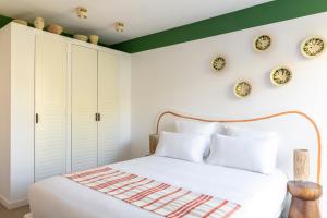 a bedroom with a white bed and plates on the wall at Hôtel Le Sud in Juan-les-Pins
