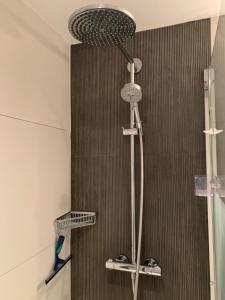 een douche met een douchekop in de badkamer bij Appartement met zeezicht in Blankenberge