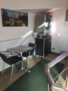 eine Küche mit einem Tisch und Stühlen im Zimmer in der Unterkunft Pensiune Turist in Sibiu