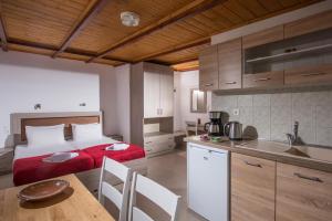 a bedroom with a bed and a kitchen with a table at Hotel Aglaia in Kalamaki