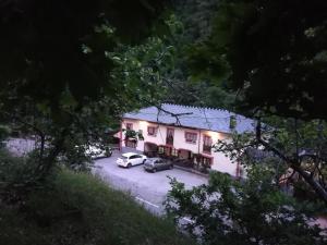 ein Haus mit zwei Autos auf einem Parkplatz in der Unterkunft Casa de Aldea La Pescal in La Pescal