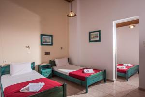a room with two beds and a mirror at Hotel Aglaia in Kalamaki