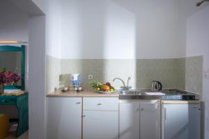 a kitchen with a sink and a bowl of fruit at Hotel Aglaia in Kalamaki