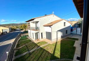 una pequeña casa blanca con una valla al lado de una calle en Las Casetas de Mateu, en Torres del Obispo