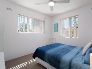 a bedroom with a bed and two windows at Krait Court, 1 6-8 Krait Cl - great 2 bedroom unit close to little beach in Nelson Bay