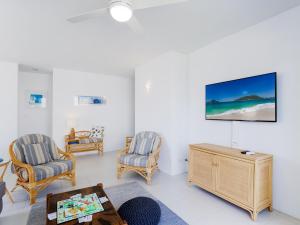 a living room with two chairs and a tv on the wall at Krait Court, 1 6-8 Krait Cl - great 2 bedroom unit close to little beach in Nelson Bay
