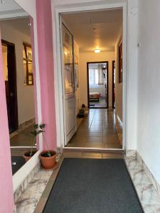 a hallway with pink and white walls and a hallway with plants at Pensiune Turist in Sibiu
