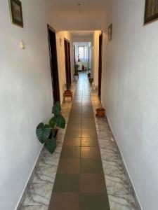 a hallway with a tile floor and a hallway with plants at Pensiune Turist in Sibiu
