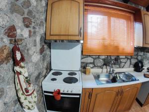 a small kitchen with a stove and a sink at Patras stonehouse with large yard - Πέτρινο σπίτι με αυλή in Paralía