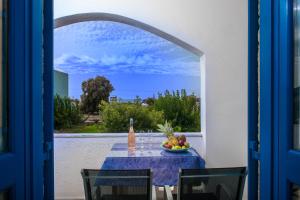 a table with a bowl of fruit and a bottle of wine at Hotel Aglaia in Kalamaki +23 photos