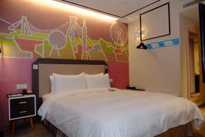 um quarto com uma cama branca e uma parede colorida em Uinn Business Hotel-Shihlin em Taipei