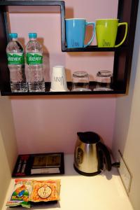 a kitchen counter with a cup of coffee and a bottle of water at Uinn Business Hotel-Shihlin in Taipei