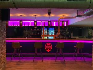a bar with pink lights on the wall at Altstadthotel Arte in Fulda +46 photos