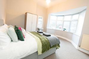 a bedroom with a bed with pillows and a window at The Harrogate Abode in Harrogate