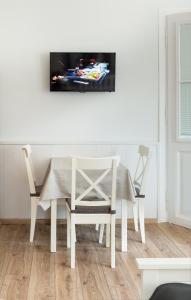 a dining room with a white table and chairs at Provence Apartmanok in Visegrád