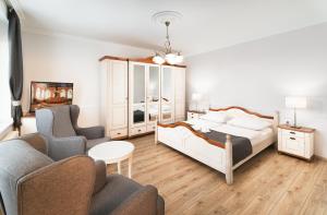 a bedroom with a bed and a living room at Provence Apartmanok in Visegrád