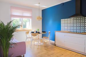 a kitchen with a blue wall and a table and chairs at Apartamenty Skarpa in Mysłakowice