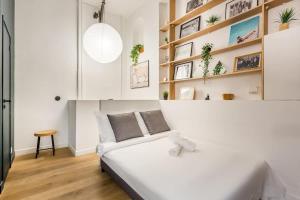 Un dormitorio blanco con una gran cama blanca y estanterías en SLEEPOO - Cocooning 6 en París