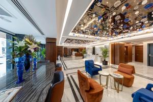 a lobby with a glass table and blue chairs at Vital Hotel Fulya Istanbul Sisli in Istanbul