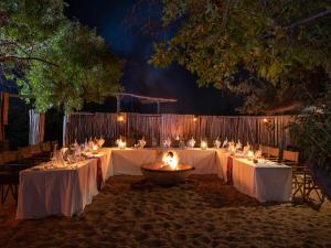 a table set up for a wedding on the beach at night at Tintswalo Waterberg in Vaalwater