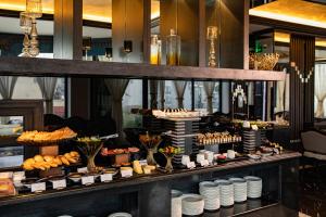 uma linha de buffet com sobremesas e produtos de pastelaria em exposição em La Sinfonía del Rey Hotel & Spa em Hanói