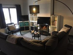 een woonkamer met een bank en een open haard bij vakantiehuisje 007 in Koksijde