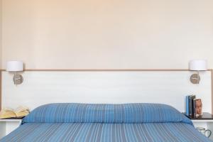 una camera da letto con un letto con due lampade sopra di Happy Sea Home Monolocale Angolo Cottura 4 pax ad Albinia