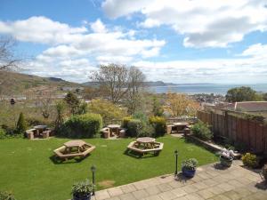 a garden with picnic tables and a view of the water at The Mariners Hotel in Lyme Regis